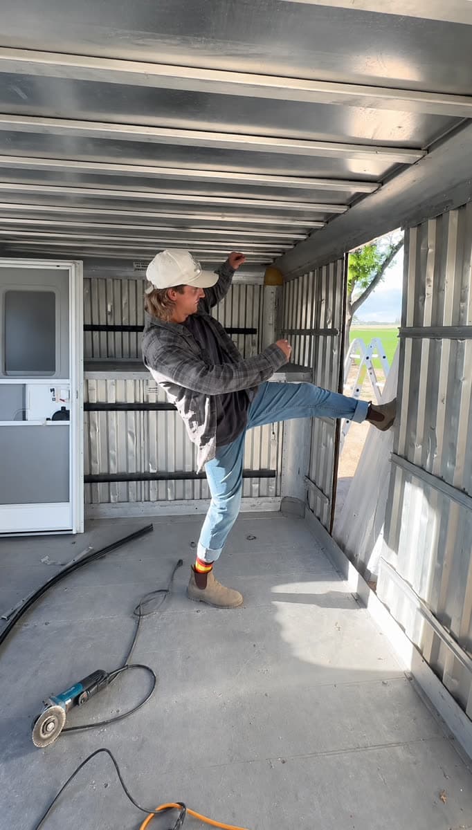 Matt inside the stripped bare-metal cargo box during the build